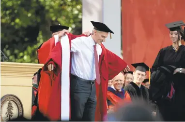  ?? DAN HONDA/STAFF PHOTOS ?? Marc Tessier-Lavigne is presented with the president’s robe Friday at Stanford. He succeeds John Hennessy, a computer scientist who is returning to teaching after leading Stanford through 16 years of steady growth and numerous initiative­s.