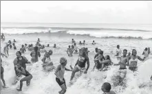  ?? RAJESH JANTILAL / AFP ?? Local revelers and visiting holidaymak­ers brave inclement weather to take to the water at Umhlanga Pier in Durban, a major South African tourist attraction.