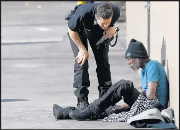  ?? Mark Boster Los Angeles Times ?? A PARAMEDIC talks to a homeless man during a 2016 skid row sweep by police and sanitation workers. One homeless advocate said citations can sometimes be a tool to persuade homeless people to seek out services.