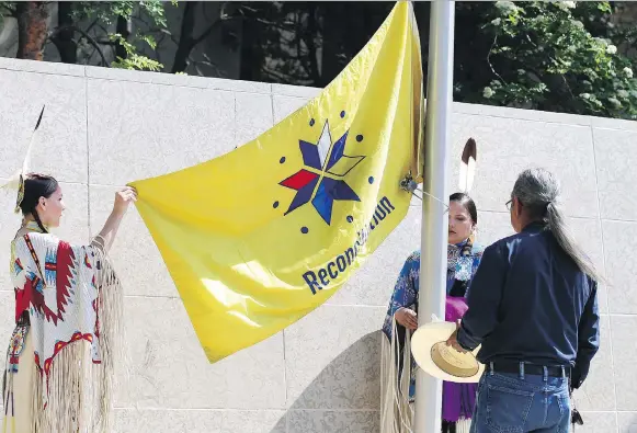  ?? MATT OLSON ?? Attendees raise the reconcilia­tion flag at city hall on Tuesday. Speakers noted more has to be done, but expressed optimism that Saskatoon is moving in the right direction.