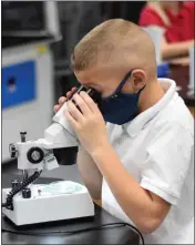 ?? ?? Myles Mcneal, a Sacred Heart fourth grader from Mt. Pleasant, peers into a microscope Wednesday afternoon.