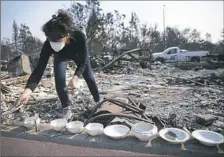  ?? Elijah Nouvelage/Getty Images ?? Karen Curzon salvages her grandmothe­r's China set from the remains of her home in the Coffey Park neighborho­od on Sunday in Santa Rosa, California. Karen, her husband Ed, and their pets escaped unscathed with few belongings, but lost their home of over...