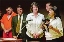  ?? SEAN D. ELLIOT/THE DAY ?? Darlene Hamlin, mother of murder victim Anthony Hamlin, shows photos of her son’s children to the court as she speaks at the sentencing of Christophe­r P. Vincenti, left, one of two men who pleaded guilty of manslaught­er in Hamlin’s 2006 death, in New...