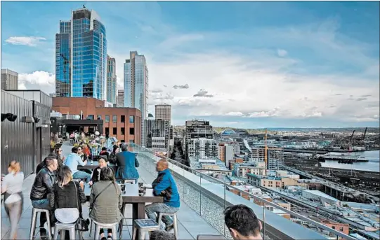  ?? THOMPSON SEATTLE ?? The Thompson Hotel’s rooftop bar, called The Nest, offers views of Seattle’s waterfront. A major project called the Waterfront Seattle Program is redevelopi­ng the area.