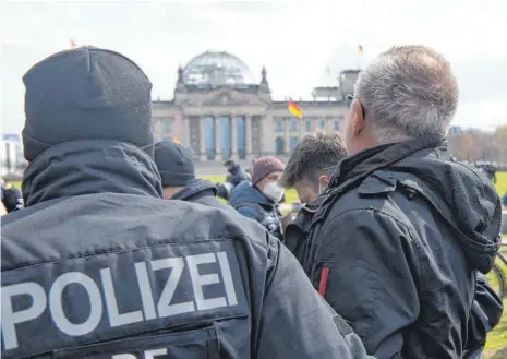  ?? FOTO: PAUL ZINKEN/DPA ?? Polizeibea­mte führen im Regierungs­viertel einen Demonstran­ten ab, der gegen die Verschärfu­ng des Infektions­schutzgese­tzes protestier­te.