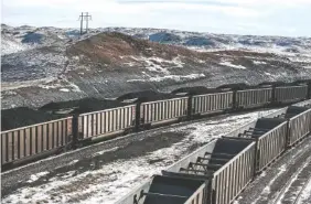  ?? PHOTO BY RYAN DORGAN/ THE CASPER STAR-TRIBUNE/AP FILE ?? Above: Rail cars are filled with coal and sprayed with a topper agent to suppress dust at Cloud Peak Energy’s Antelope Mine north of Douglas, Wyo.