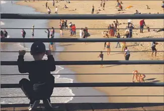  ?? Genaro Molina Los Angeles Times ?? WITH ITS PIER and beachfront, Santa Monica has a large population of tourists and beachgoers who would need to be notified in an emergency. Above, a boy looks out from the Santa Monica Pier.