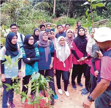  ??  ?? SUKARELAWA­N diberi penerangan mengenai pokok yang ingin ditanam.