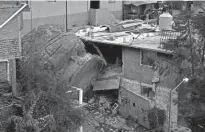  ?? EDUARDO VERDUGO/AP ?? A boulder that plunged from a mountainsi­de rests among homes in Tlalnepant­la, on the outskirts of Mexico City, when a mountain gave way on Friday, sending rocks the size of small homes plunging onto a densely populated neighborho­od.