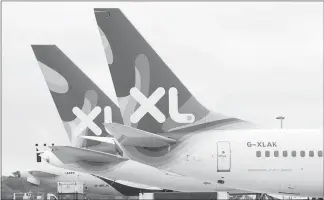  ?? STEVE REIGATE, POOL / AP FILE (2008) ?? Tailfins of XL Airways planes are seen as they stand on the tarmac at Gatwick Airport in London. When considerin­g low-cost, long-haul carriers, keep in mind that you’re generally not buying much more than a seat.