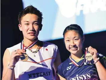  ?? Ahmed Ramzan/Gulf News ?? Golden pair Kento Momota (left) and Nozomi Okuhara from Japan pose with their medals after winning the finals of Dubai World Superserie­s finals at Hamdan Complex in Dubai on Sunday.