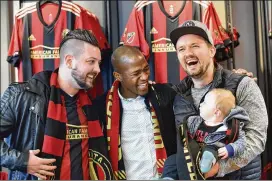  ?? HYOSUB SHIN / HSHIN@AJC.COM ?? Darlington Nagbe laughs with fans Adam Boyle (left) and Andrew Amerson, with his son Elon, as they pose for a photo at Mercedes-Benz Stadium.