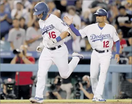  ?? Photograph­s by Luis Sinco Los Angeles Times ?? WILL SMITH is greeted by third base coach Dino Ebel after hitting a two-run homer in the third inning for a 3-2 lead.