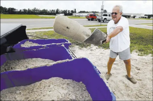  ?? Rogelio V. Solis The Associated Press ?? George Estes tosses sand into storage tubs at a Gulfport, Miss., sand bagging location in preparatio­n for Subtropica­l Storm Alberto.