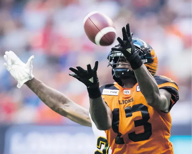  ?? — THE CANADIAN PRESS ?? Lions receiver Kevin Elliott catches a pass over Edmonton defender Chris Edwards in the first half of a 31-23 come-from-behind Lions victory at B.C. Place Thursday night. It was a win B.C. desperatel­y needed to keep pace in the Western Division standings.