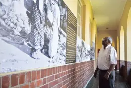  ??  ?? The director of the centre, Juggie Pather, looks at some of the photograph­s and stories along the passage walkway.