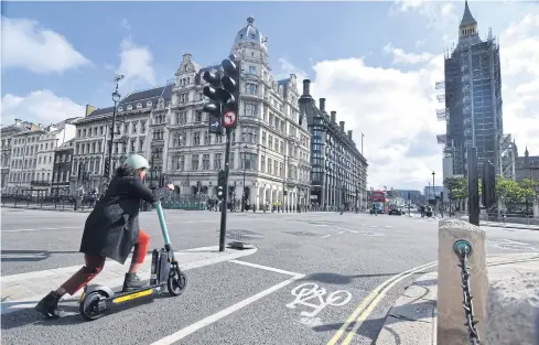  ?? PHOTOS BY REUTERS ?? Georgia Yexley, UK and Ireland head of cities at micromobil­ity firm Tier, demonstrat­es how to ride an e-scooter in London.