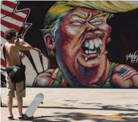  ??  ?? A man takes pictures of graffiti depicting Republican presidenti­al candidate Donald Trump in Barcelona, Spain, on Tuesday.