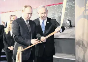  ??  ?? Russia’s Vladimir Putin, left, cuts a ribbon with Israel’s Benjamin Netanyahu during the dedication of a monument in Jerusalem honouring the veterans and victims of the siege of Leningrad in the Second World War