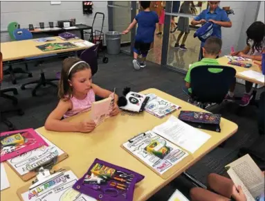  ?? BILL DEBUS — THE NEWS-HERALD ?? Addy Dietrick, a third-grader at Ridge Elementary School in Mentor, reads a book during the first day of classes on Aug. 16.