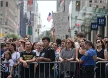  ?? The Associated Press ?? People line Fifth Avenue on Wednesday as they watch President Donald Trump’s motorcade leave Trump Tower in New York. Trump on Wednesday disbanded a pair of advisory business councils — the latest fallout from his comments on racially charged violence...