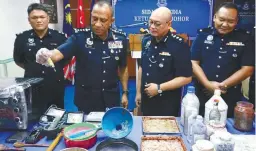  ??  ?? Mohd Khalil (second from left) showing a seized apparatus for making Ecstasy pills.