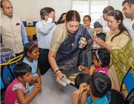  ?? — PTI ?? Union minister for textiles Smriti Irani serves food among blind children at a school for blind children in R. K. Puram, New Delhi, on Monday.