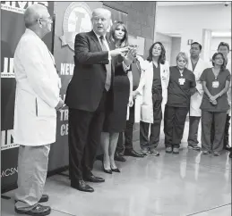  ?? DOUG MILLS / THE NEW YORK TIMES ?? President Donald Trump and first lady Melania Trump with doctors and medical workers after visiting shooting victims on Wednesday at University Medical Center. Trump paid tribute to the profession­alism of the doctors who treated the
Las Vegas shooting...
