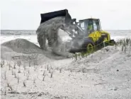  ?? BOB MACK/THE FLORIDA TIMES-UNION VIA AP ?? A Jacksonvil­le Beach public works front loader moves sand to fortify dunes near the Jacksonvil­le Beach Fishing Pier on Friday to help with a possible storm surge from Hurricane Irma.