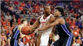  ?? RICHARD SHIRO — THE ASSOCIATED PRESS ?? Clemson’s Aamir Simms grabs a rebound while defended by Duke’s Vernon Carey Jr. during the first half of an NCAA college basketball game Tuesday in Clemson, S.C.