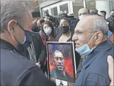  ?? Wally Skalij Los Angeles Times ?? L.A. POLICE Chief Michel Moore, left, talks to community leaders outside police headquarte­rs after a vigil for George Floyd.