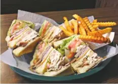  ?? PHOTO BY BEN BENTON ?? The Snack Shack’s club sandwich, here with a side of golden crinkle fries, is a formidable mix of thick wedges of ham, turkey, roast beef, bacon and American cheese lubricated with mayonnaise and topped with lettuce, tomato, pickle and onion and...