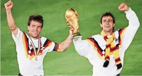  ??  ?? West German midfielder Lothar Matthaeus (left) and forward Pierre Littbarski celebratin­g with the World Cup trophy in 1990 in Rome after beating Argentina in the World Cup final. The white West Germany top, featuring a tricolour band of the national...