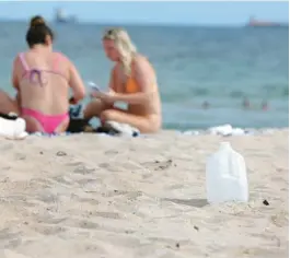  ?? CARLINE JEAN/SOUTH FLORIDA SUN SENTINEL ?? Hydration is all the rage these days, but single-use plastic often ends up in the ocean. Some plastics can break down into nanoplasti­c particles small enough to end up in fish, and in the human bloodstrea­m. This plastic water jug was left behind during Spring Break on Fort Lauderdale beach.