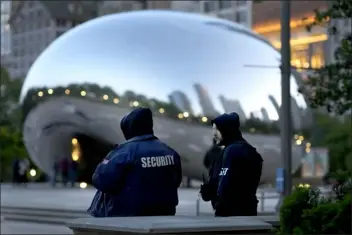  ?? CHARLES REX ARBOGAST — THE ASSOCIATED PRESS ?? *Private security personnel patrol the area around Anish Kapoor’s stainless steel sculpture Cloud Gate, also known as “The Bean,” in Chicago’s Millennium Park Thursday, May 25, 2023. Chicago is heading into the Memorial Day weekend hoping to head off violence that tends to surge with rising temperatur­es of summer. Even the state of Illinois is assisting by sending in what it’s called “peacekeepe­rs” in an attempt to deescalate violent situations.