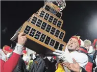  ?? JACQUES BOISSINOT THE CANADIAN PRESS ?? Calgary University Dinos’ Adam Sinagra raises the Vanier Cup in Quebec City last November. Athletic seasons for the 2020-21 academic year are in jeopardy because classes are moving online.