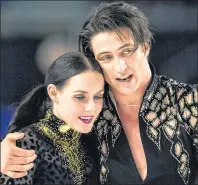  ?? CP PHOTO ?? Tessa Virtue and Scott Moir skate off the ice after performing their short program during the ice dance competitio­n at the Canadian figure skating championsh­ips in Vancouver, B.C., on Friday.