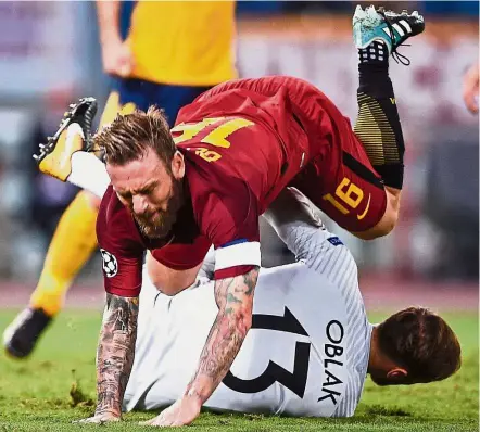  ??  ?? AS Roma’s Daniele De Rossi stumbling over Atletico Madrid goalkeeper Jan Oblak in the Champions League Group C match in Rome on Tuesday. The match ended 0- 0. — AFP Collision: