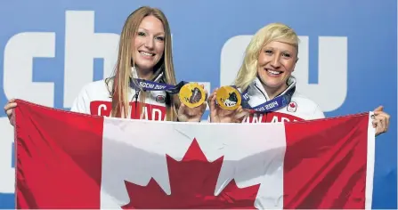  ?? POSTMEDIA NETWORK FILES ?? Bobsledder­s Heather Moyse and Kaillie Humphries pose for photos after winning gold at the 2014 Olympic Winter Games in Sochi, Russia.