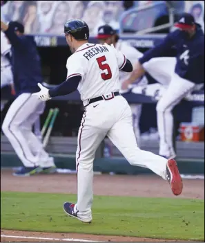  ?? Associated Press ?? WINNER — Atlanta Braves Freddie Freeman (5) runs to first after hiting a gamewinnin­g base hit against the Cincinnati Reds in the 13th inning during Game 1 of a National League wild-card series on Wednesday in Atlanta. The Braves won 1-0.