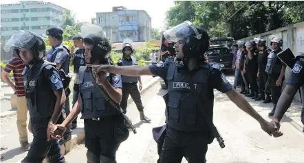  ?? — GETTY IMAGES ?? Bangladesh­i police stand guard at the scene of an operation to storm a militant hideout Saturday in Narayangan­j, about 25 kilometres south of the capital Dhaka. Tamim Ahmed Chowdhury, who spent many years in Windsor, Ont., died during an exchange of...