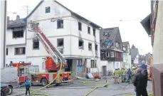  ?? FOTO: SBO ?? Ein Bild der Verwüstung bietet das Mehrfamili­enhaus an der Ecke Mutzenbühl­und Lessingstr­aße am Tag nach dem Brand. Feuerwehr und Polizei sind unter den Blicken einiger Passanten nach wie vor im Einsatz.