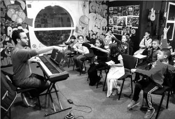  ??  ?? Local Moroccan children attend a music class at the Stars Cultural Centre in Casablanca’s northeaste­rn suburb of Sidi Moumen on Nov 24, 2017. Based in a white building next to a tramline and opposite a mosque, the Stars Cultural Centre regularly hosts...