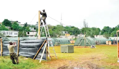  ?? IAN ALLEN/PHOTOGRAPH­ER ?? Members of the Jamaica Defence Force preparing a base camp in Norwood, St James yesterday, on the second day of the public state of emergency for the parish.