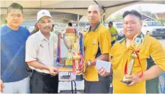  ??  ?? Janudin (second left) presents the Challenge Trophy to Brunei team players.