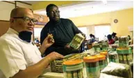  ??  ?? Zimbabwe entreprene­ur Shepherd Mafundikwa (right) confers with business technical partner Dominican cigar maestro, Elias Lopez (left), at a display of some of his company’s hand rolled cigars.