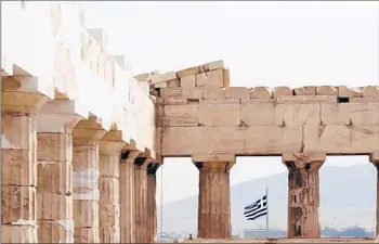  ?? JOHN KOLESIDIS/REUTERS ?? A Greek flag waves behind the columns of the temple of the Parthenon.