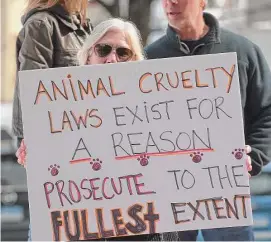  ?? H John Voorhees III/Hearst Connecticu­t Media ?? Protesters wait for Michael Konschak outside of Danbury Superior Court on Wednesday morning. Konschak is facing charges after he allegedly killed, beheaded and skinned a family’s dogs.