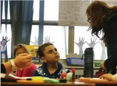  ?? STEVE RUSSELL/TORONTO STAR FILE PHOTO ?? Teacher Joanne Mitchell explains a task to 10-year-old Ibrahim al Sultan, a newcomer from the battered city of Homs, Syria.