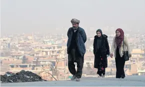  ??  ?? TURNING POINT NEARS: A man walks along with women on a hillside overlookin­g Kabul as a oneweek cessation of hostilitie­s took hold last week.